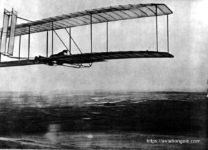 One of the successful glides made in October 1902 with the 1902 glider, camp buildings in distance